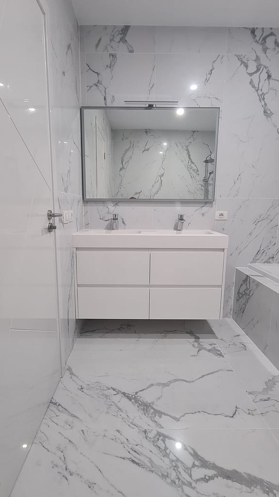 Reforma de cuarto de baño grande con revestimiento con piezas gran formato marmoleado